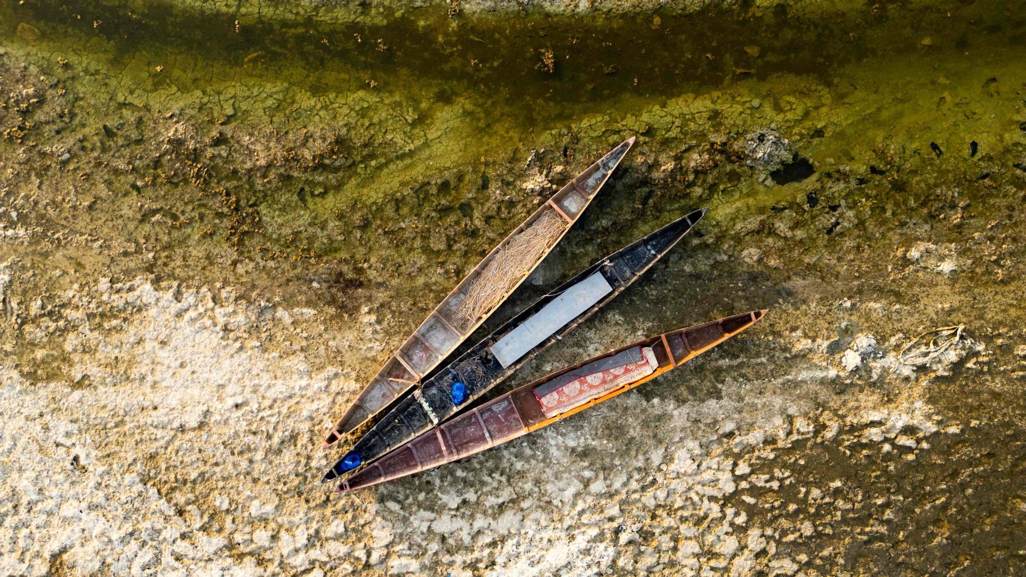 تظهر قوارب صيد خشبية تقليدية مهجورة في أهوار جافة بمحافظة البصرة جنوب العراق