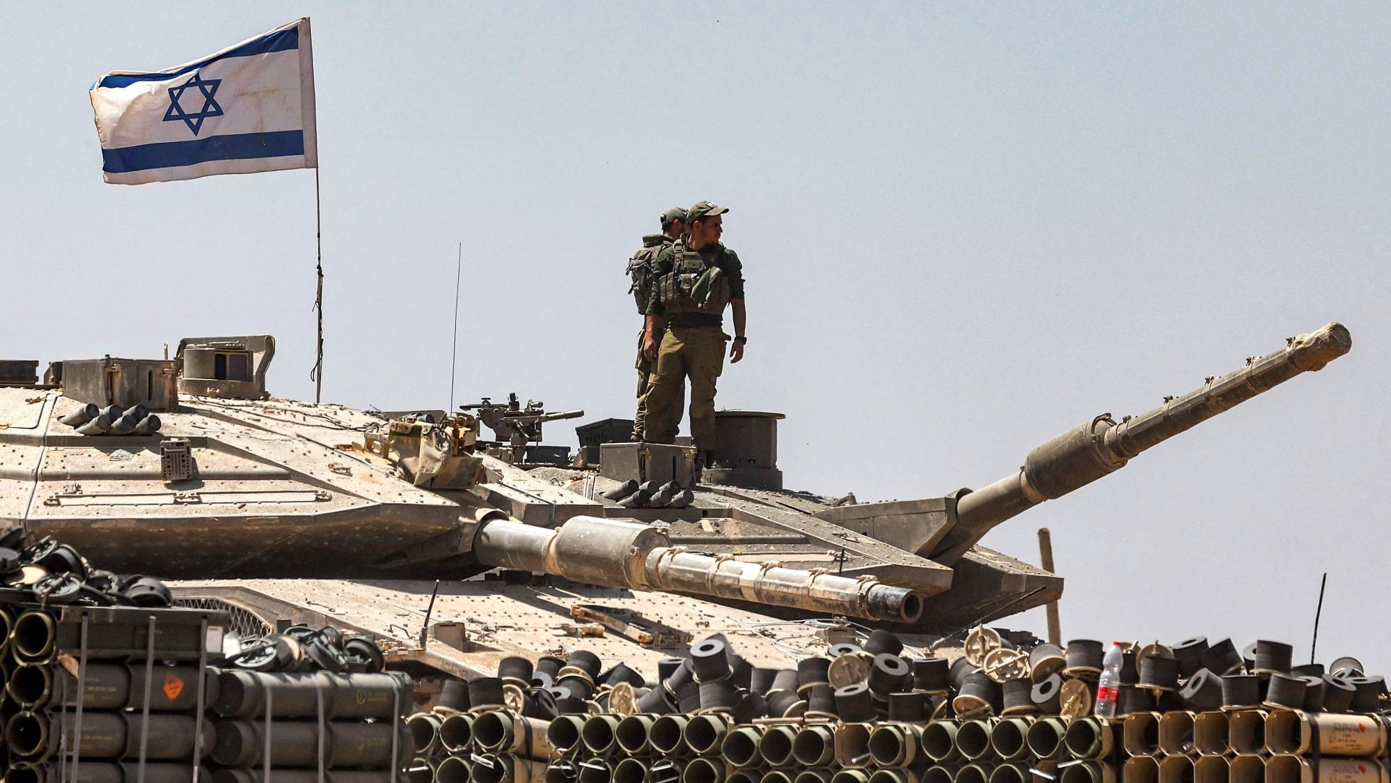 جنود من الجيش الإسرائيلي يقفون فوق برج دبابة متمركزة في جنوب إسرائيل بالقرب من الحدود مع قطاع غزة