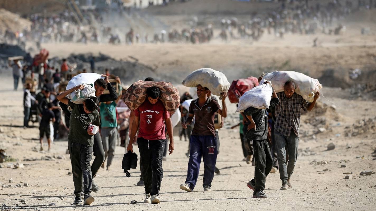 فلسطينيون يحملون أكياساً من المساعدات بقرب معبر نتساريم وسط قطاع غزة