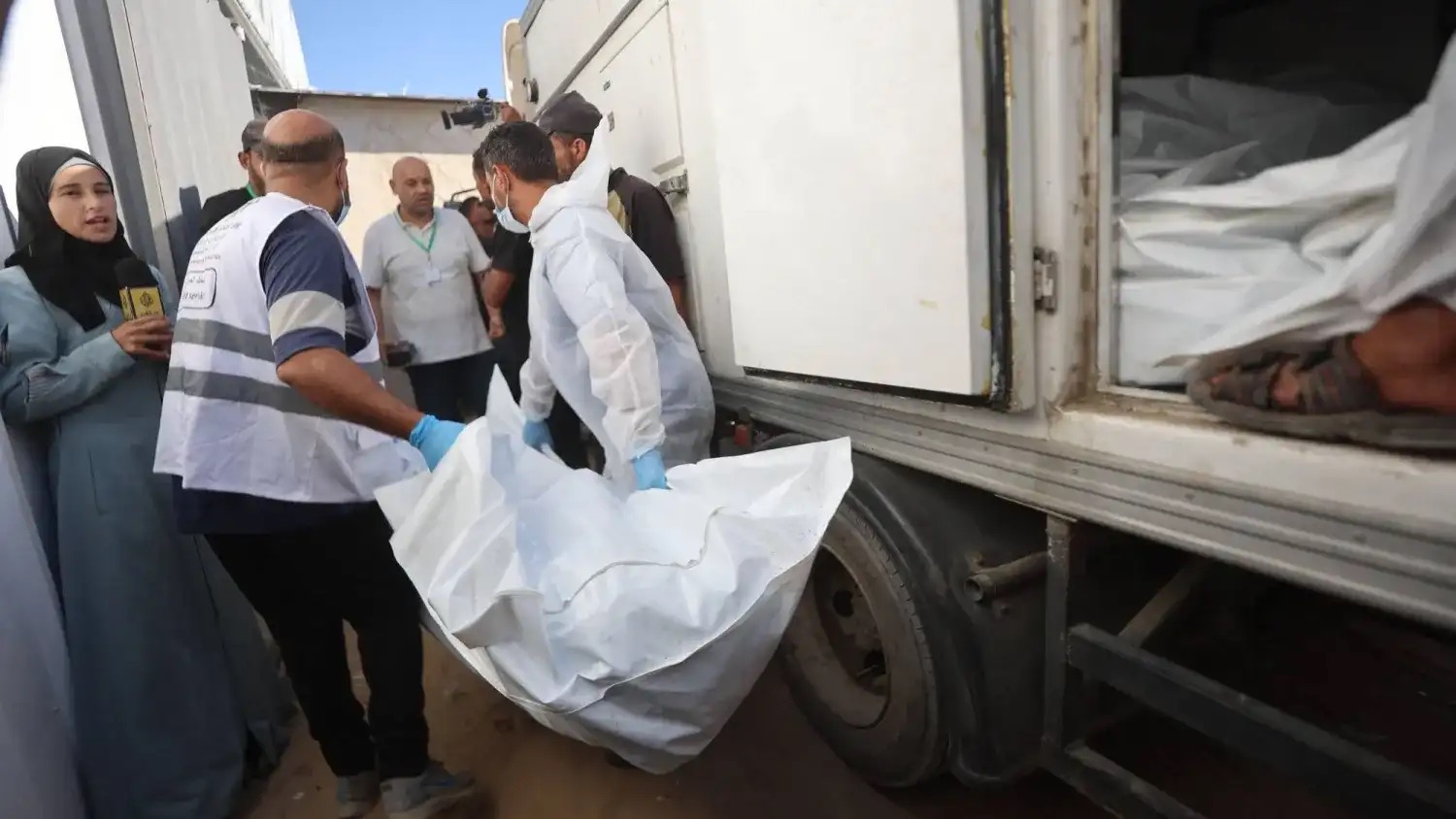 عاملون في المشرحة يقومون بنقل جثامين فلسطينيين كانت محتجزة لدى إسرائيل إلى مستشفى ناصر في خان يونس الأربعاء