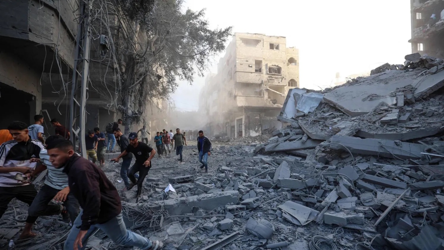 فلسطينيون يفرون من موقع استهدفته ضربة إسرائيلية في مخيم البريج للاجئين وسط قطاع غزة