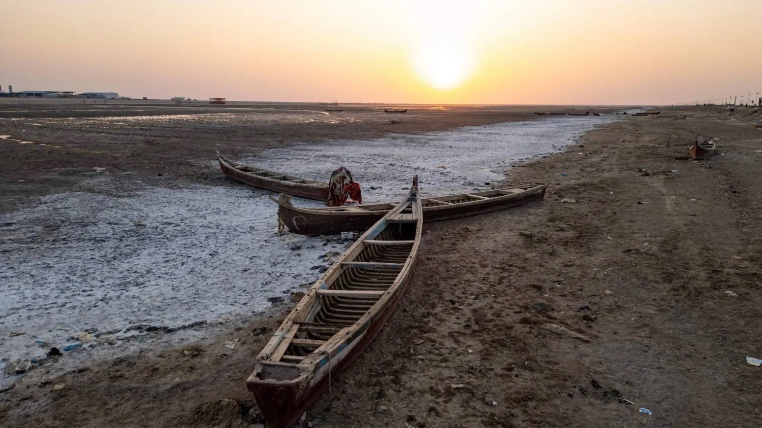 قوارب صيد خشبية تقليدية مهجورة في أهوار جافة بمحافظة البصرة جنوب العراق