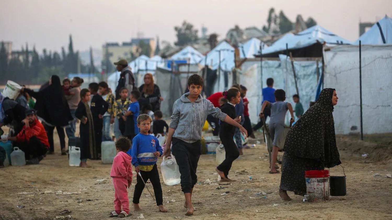 فلسطينيون يملأون حاوياتهم بالمياه في مخيم النصيرات للنازحين الفلسطينيين وسط قطاع غزة