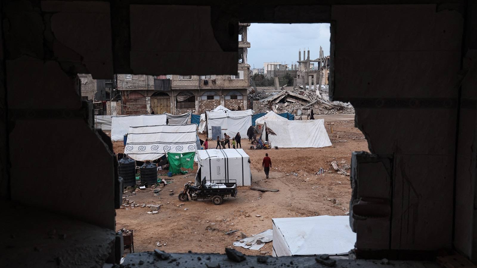 فلسطينيون نازحون يمرون بجوار الخيام في مخيم البريج