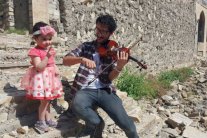 عازف عراقي يقيم حفلاً وسط الدمار