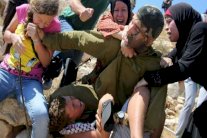 نساء يخلصن طفلا فلسطينيا من أيدي جندي إسرائيلي 