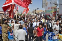 رايات الاحزاب تحجب علم العراق