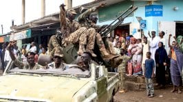 أشخاص يهتفون لأعضاء القوات المسلحة السودانية المشاركين في عرض عسكري أقيم في يوم الجيش يوم 14 أغسطس 2024