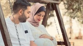 رجل وامرأة حامل يجلسان معًا على الأرجوحة - Huda M