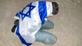 جنود إسرائيليون يعتقلون فلسطينياً ويغطونه بالعلم الإسرائيلي