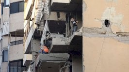 أشخاص يتفقدون مبنى متضرر، بعد هجوم إسرائيلي على الضاحية الجنوبية لبيروت، 23 نوفمبر/تشرين الثاني 2025 - Reuters