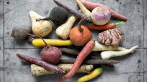 خضروات مختلفة (جزر، لفت، زنجبيل…) على سطح رمادي اللون - Getty Images