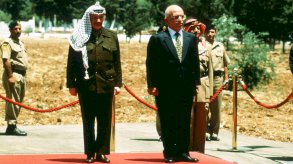 رئيس منظمة التحرير الفلسطينية ياسر عرفات يقف إلى جانب الملك حسين خلال زيارة رسمية في 17 مايو/أيار 1998 في عمّان، الأردن. - Getty Images