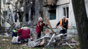 عمال يقومون بتنظيف الحطام خارج مبنى سكني تضرر خلال غارة روسية ليلية بطائرة بدون طيار وصاروخ، وسط هجوم روسيا على أوكرانيا، في كييف. - Reuters