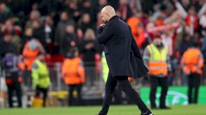 مدرب ليفربول، آرني سلوت يبدو واقفاً على أرضية الملعب، يرتدي 