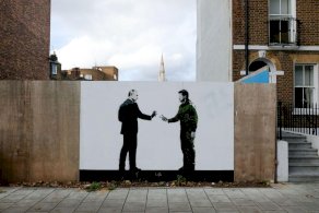 رسم على جدار يتضمّن بوتين وزيلينسكي - Getty Images