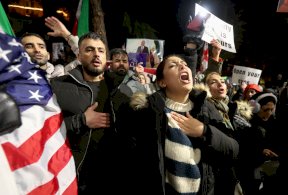 عدد من المتظاهرين في مسيرة تضامنية يهتفون - Reuters