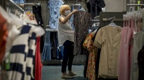 امرأة تتسوق في مونتريال (كندا) وهي تضع الكمامة. وفي ظلّ العزل العام، شهدت التجارة الإلكترونية نموّا شديدا هذا العام.