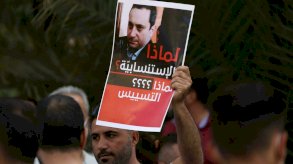 لافتة تحمل صورة القاضي طارق بيطار المحقق العدلي في انفجار مرفأ بيروت، يرفعها متظاهر معارض للقاضي في العاصمة اللبنانية بتاريخ 14 تشرين الأول/أكتوبر 2021