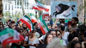 أشخاص يرفعون لافتات وأعلامًا إيرانية خلال تظاهرة في نيويورك تضامنًا مع النساء الإيرانيات في 16 أيلول/سبتمبر 2023 في الذكرى الأولى لوفاة الشابة مهسا أميني