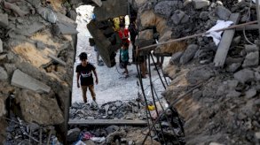 أطفال فلسطينيون وسط الأنقاض في رفح بجنوب قطاع غزة، 3 أيار (مايو) 2024. 