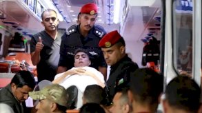 عناصر من قوات الأمن الأردني خلال استقبال طفل فلسطيني مريض أجلي من قطاع غزة لتلقي العلاج في المملكة