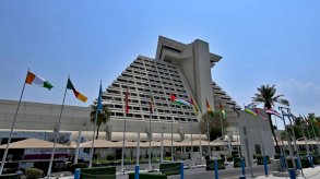 أعلام مرفوعة على مدخل الفندق الذي تعقد فيه القمة العربية الإسلامية في العاصمة القطرية (أ ف ب)