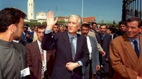 وزير الخارجية الجزائري الأسبق والمرشح للرئاسة أحمد طالب الإبراهيمي يلوّح لمناصريه في 6 أبريل/نيسان 1999 في مدينة البليدة، خلال حملته الانتخابية للانتخابات الرئاسية. - Getty Images