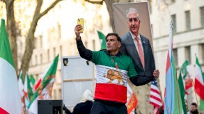 متظاهر إيراني يلتقط سيلفي مع صورة بهلوي الإبن