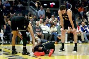 جيمي باتلر على الارض بعد تعرضه لاصابة في الركبة وإلى جانبه ستيفن كوري وكوينتين بوست خلال مباراة فريقه ولدن ستايت ووريرز مع ميامي هيت في سان فرانسيسكو في 19 كانون الثاني/يناير 2026