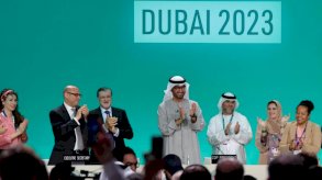 رئيس COP28 سلطان أحمد الجابر (في الوسط) يصفق بين المسؤولين الآخرين قبل الجلسة العامة خلال قمة الأمم المتحدة للمناخ في دبي في 13 ديسمبر 2023 