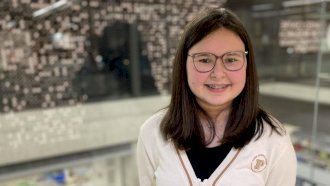 فتاة مراهقة ذات شعر داكن تبتسم للكاميرا وهي ترتدي سترة بيضاء. - BBC