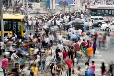 يتحوّل العدد الهائل من المشاة الذين يعبرون التقاطع المزدحم في منطقة التسوّق