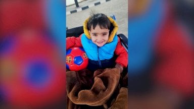 الطفل أحمد الشبت في رحلة علاجه بعد أن فقد ساقيه. - BBC