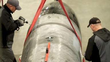 يقوم رجلان بتجميع صاروخ فلامنغو الجديد، وهو صاروخ كروز أوكراني بعيد المدى، مصمم لشن ضربات بعيدة المدى ضد روسيا برأس حربي يزيد وزنه عن طن ومدى يصل إلى 3000 كيلومتر. - Moose Campbell/BBC