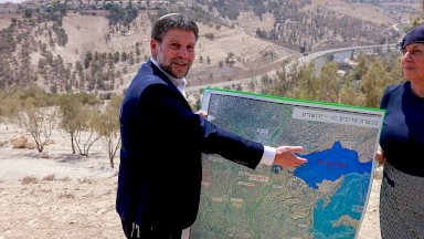 الوزير الإسرائيلي بتسلئيل سموتريش يشير في الخريطة إلى مشروع إي وان الاستيطاني، الذي يفصل بين القدس الشرقية المحتلة والضفة الغربية المحتلة - AFP via Getty Images