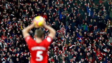 جانب من مباراة في الدوري الإنجليزي الممتاز ويظهر في الصورة مشجعين يعتمرون قبعات بالتزامن مع عيد الميلاد - Getty Images