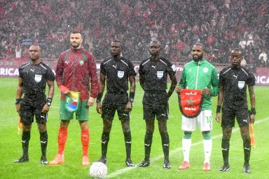 قائدا المنتخبين المغربي وجزر القمر يقفان مع حكام اللقاء قبل انطلاق مباراة الافتتاح في كأس أفريقيا لكرة القدم على ملعب الأمير مولاي عبد الله في الرباط - Anadolu via Getty Images