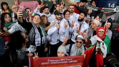 رياضيون فلسطينيون يتوسطون الجماهير المتعاطفة في مطار شارل ديغول في فرنسا. الخميس 25 تموز (يوليو) 2024