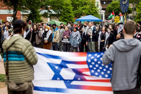 اثنان من أنصار إسرائيل يحملان العلم الأميركي والإسرائيلي أمام المتظاهرين المؤيدين للفلسطينيين في جامعة جورج واشنطن