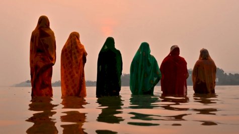 نساء هندوسيات في نهر براهمابوترا خلال مهرجان ديني في غواهاتي. 14 نيسان (أبريل) 2024