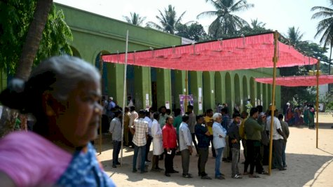 ناخبون في الهند ينتظرون التصويت وهم يحتمون من اشعة الشمس تحت مظلة في بنغالور في 26 نيسان (أبريل) 2024 