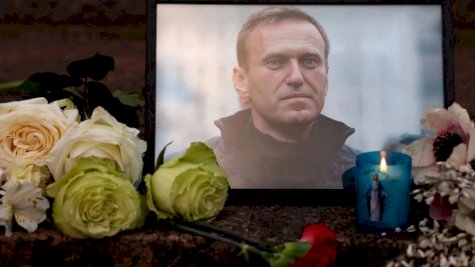 صورة لألكسي نافالني وضعت وسط الشموع والزهور تُركت في نصب تذكاري في باريس في 16 شباط (فبراير) 2024، بعد الإعلان عن وفاته