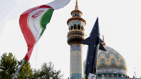 إيرانيون يرفهون علما ومجسم صاروخ أثناء احتفالات عقب الهجوم بالصواريخ والمسيرات على إسرائيل بتاريخ 15 نيسان (أبريل) 2024 في وسط طهران