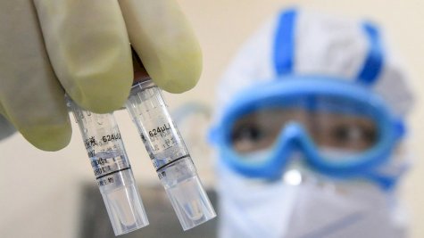 فني يحمل عينات من الفيروس في مختبر في هنغيانغ، الصين، في شباط (فبراير) 2020.