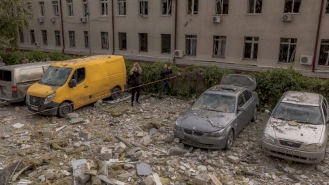 رجال يقفون بين الركام أمام مبنى سكني تضرر نتيجة هجوم صاروخي في خاركيف 14 أيار (مايو) 2024