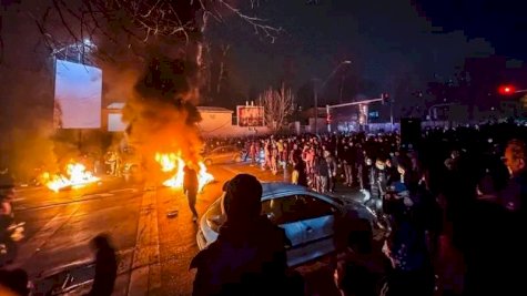 متظاهرون إيرانيون يتجمعون في أحد شوارع طهران خلال اليل وتظهر ألسنة اللهب من إطارات محترقة - Getty Images