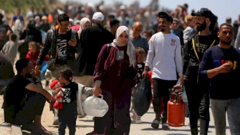 نازحون فلسطينيون يسلكون طريق رشيد الساحلي في محاولة منهم للعودة إلى مدينة غزة شمالاً أثناء مرورهم عبر النصيرات في وسط قطاع غزة في 14 نيسان (أبريل) 2024