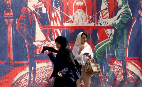 نساء يسيرن بجوار جدارية مناهضة للولايات المتحدة بالقرب من السفارة الأمريكية السابقة في طهران، إيران، 11 مايو/أيار 2025 - EPA