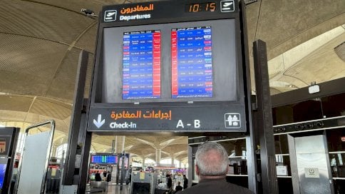 شاشة تعرض معلومات عن رحلات جوية متأخرة وملغاة في مطار الملكة علياء الدولي في عمّان - Reuters